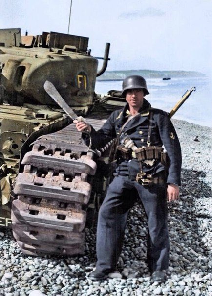 A German Marine poses next to a destroyed Churchill tank. Landing at Dieppe, 1942.