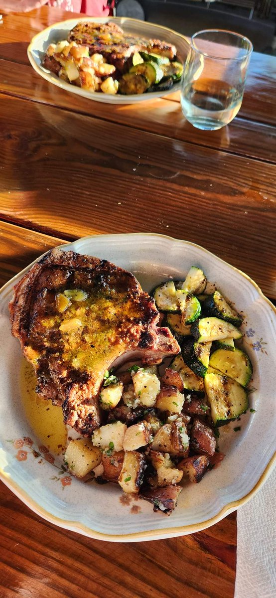 Dinner al fresco at sunset.  @<a href="/WeberGrills/">Weber Grills</a> Grilled double cut bone-in porkchops with garlic lemon jalapeno apricot glaze, grilled potatoes with fresh herbs from the garden, and fresh grilled zucchini.