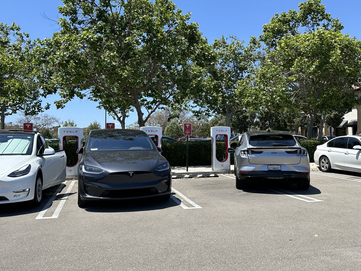 📍Goleta, CA Making it work since @TeslaCharging hasn’t removing the parking bricks here yet. Swamped Supercharger next to a swamped @ElectrifyAm w/ 1 dispenser down in a busy shopping center w/ a farmers market today. 🥵