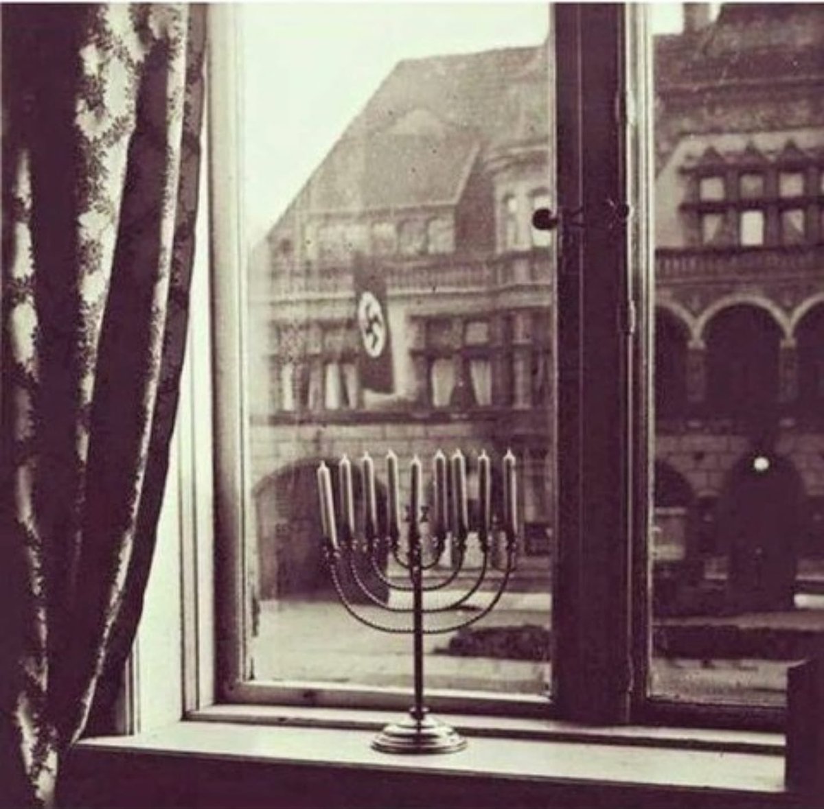 A Hanukkah menorah defiantly displayed in the window of an apartment directly across from Nazi party HQ. (1932).
Our light > Their darkness