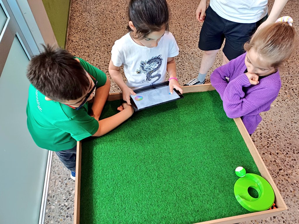 MMagdowski's tweet photo. @Ozobot @InsGraf @Sphero @SpheroEdu @TSchallschmidt @OVGUpresse @LehrstuhlEMV @KUBO_Robot @makeymakey @RatKingsLair Fleißig programmiert wurde auch an #MINTmachen-Station Nr. 4, die von Elektrotechnik-Student Niklas betreut wurde. Hier konnten die Kids der Grundschule Kritzmannstraße mit einem @Sphero-Roboter und der @SpheroEdu-App versuchen, beim Roboter-Minigolf einzulochen. https://t.co/EHjWfGXmzp