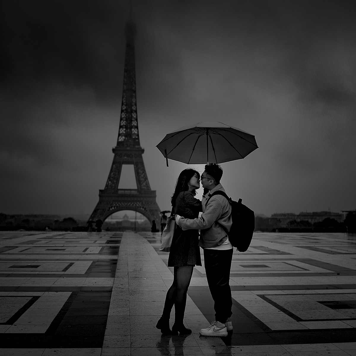 Tourists share a warm, loving embrace on a cold, wet morning at Place du Trocadéro with the Eiffel Tower surrounded by dark rain clouds. #sony #RX1R #sony#RX1Rm2 #bealpha #wetmorning #eiffeltower #paris #tourists #raining #clouds #love #sky #style #cloudy #roamtheplanet #styl ...