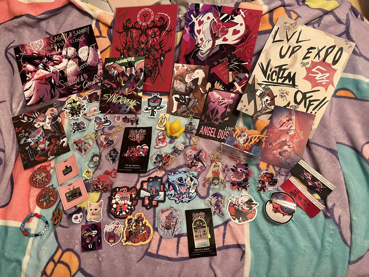 I FINALLY have a haul photo for LVLUPEXPO 2024! I can’t begin to know who to tag so feel free to tag any artists below!

A lot are gifts and I love them so much! Some highlights are the Vaggie charm gifted for my proposal 💜 and of course both Joel and Georgie’s sweet messages!