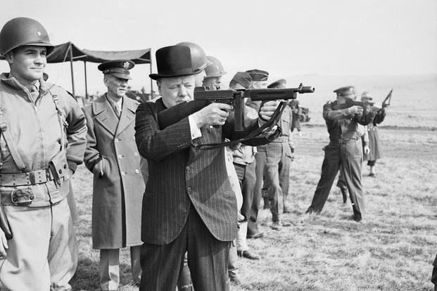 British Prime Minister Winston Churchill fires a 'Tommy' gun alongside American General Dwight D. Eisenhower, as American soldiers look on in March, 1944. #History #WWII