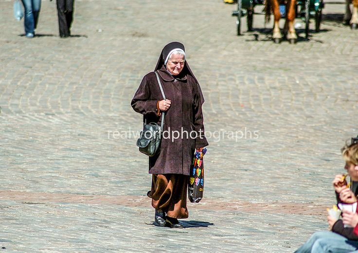 A nun walks through the Old Town in Warsaw, Poland. Gary Moore photo. Real World Photographs. #religion #nun #warsaw #poland #oldtown  #photography #garymoore #garymoorephotography #realworldphotographs #nikon #photojournalism