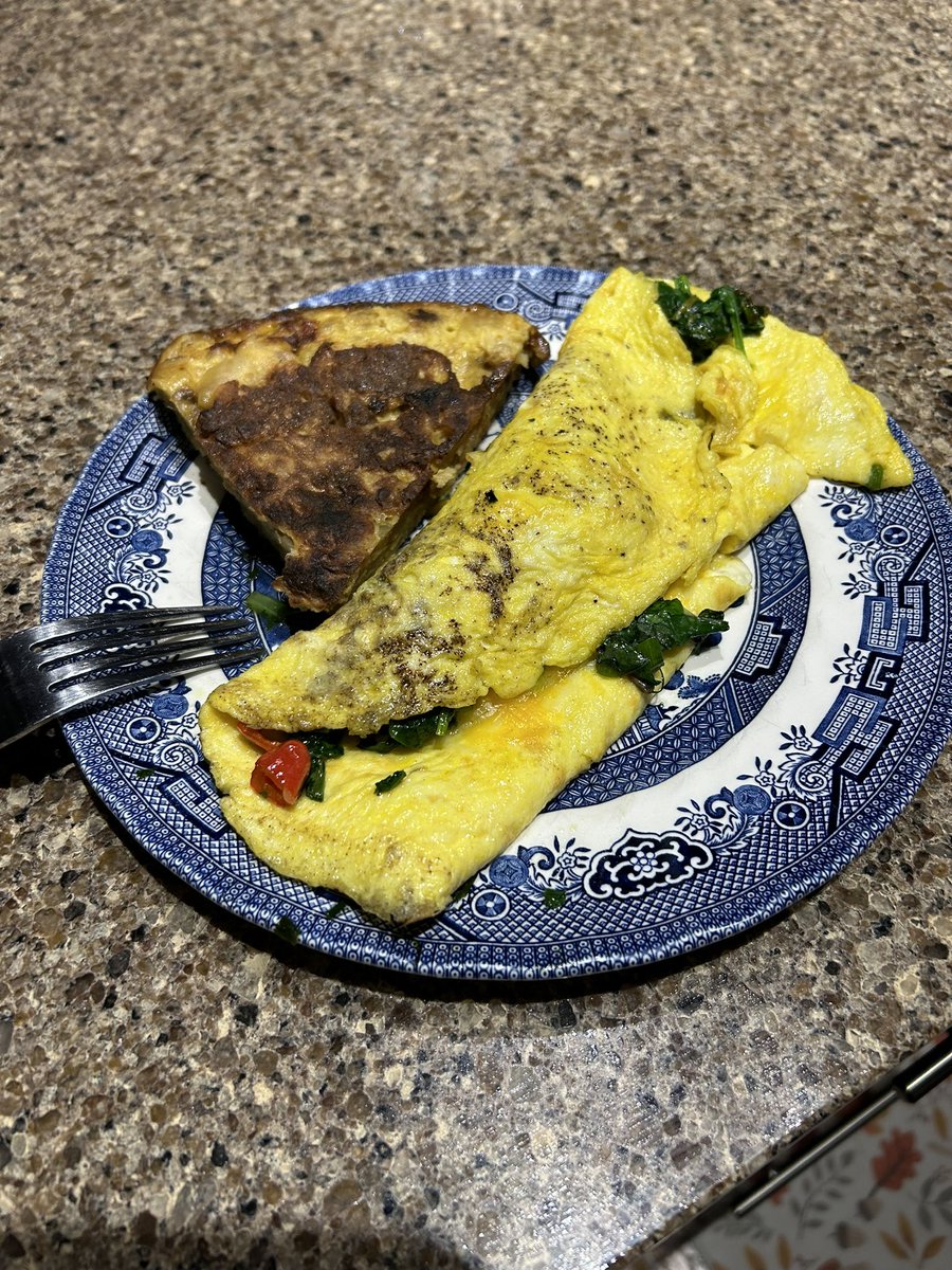 Omelette x 2. One is a leftover Tortilla de Patatas from @foodwishes and the other is 3 egg omelette from our birds with our own peppers, garlic scapes and chives, fresh spinach and mustard greens. Perfect.