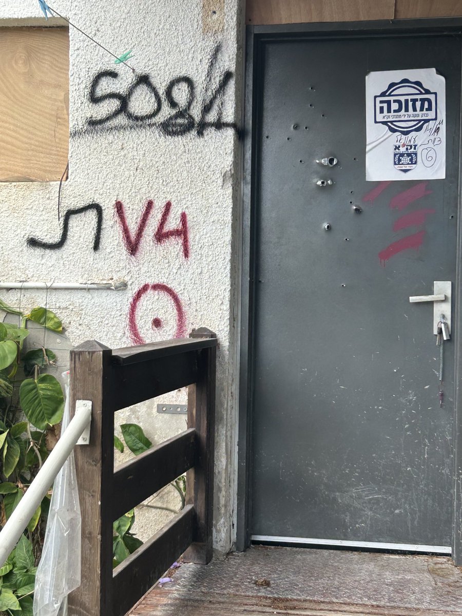 The door of the home of Elijah, a gardener. He lived alone. He was 70. They killed him in his home. The sticker means the human remains inside have been removed.