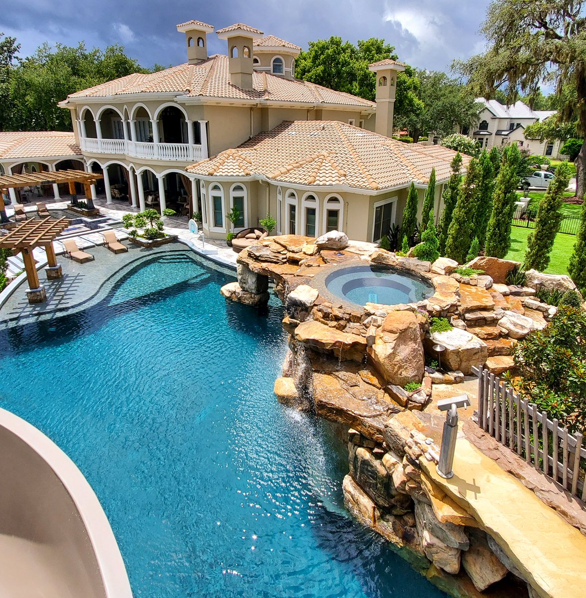 This spa is built into the top of the grotto and sits 8.5 feet above the pool below. This pool is 110 feet long, 100 thousand gallons, 168 tons of rock, and has a 140 foot long water slide. We Build Insane Pools! #insanepools #lucaslagoons #pool #poolbuilder