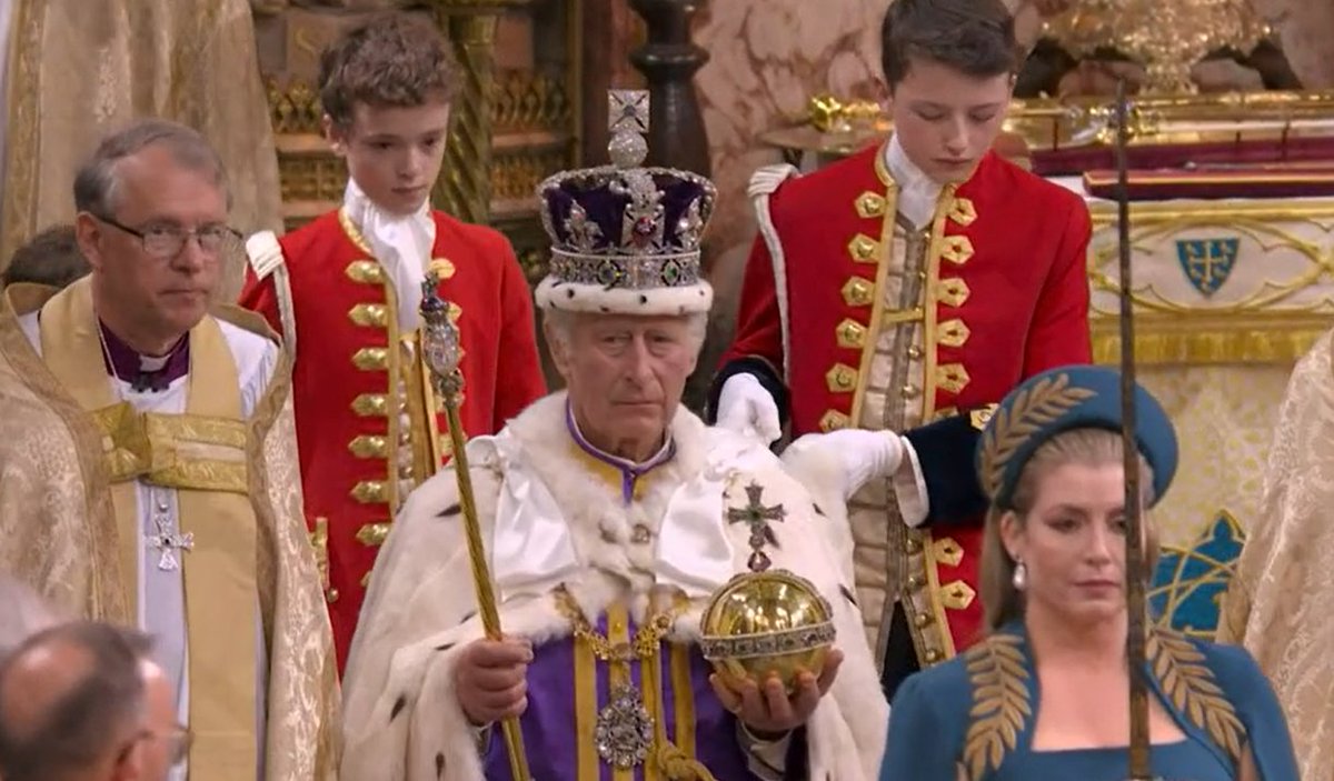 King Charles, now wearing the Imperial State Crown and the purple Robe of Estate, leaves Westminster Abbey