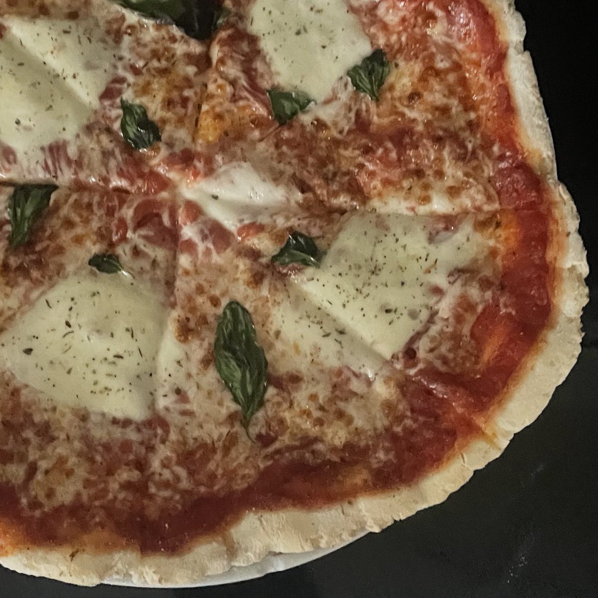 gluten free pizza with grated and slices mozzarella and basil