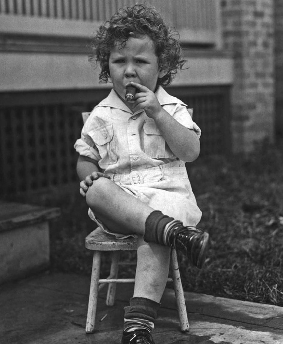 A young girl enjoying a smoke, 1914.