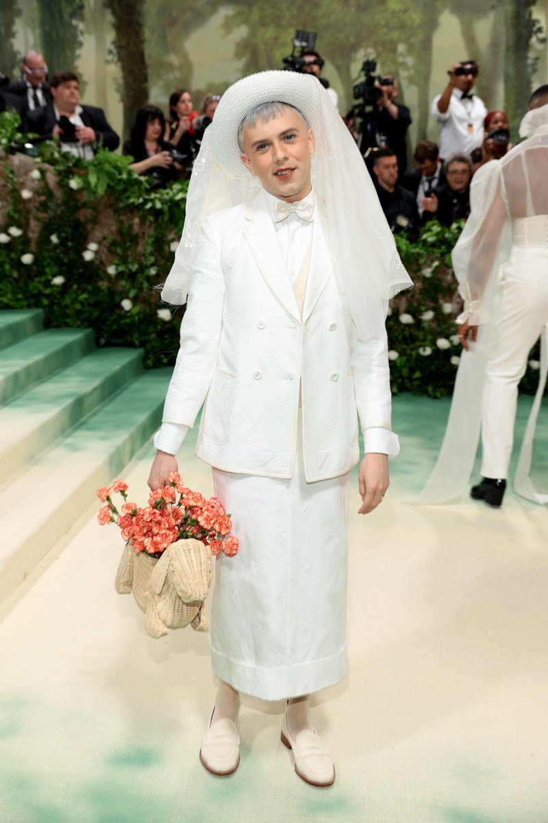 vulture's tweet photo. urgently: cole escola is at the met gala, wearing a hat, and carrying a wicker daschshund https://t.co/br1ZcoLs4m