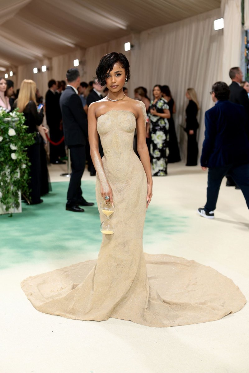 Tyla in Balmain for the Met Gala. This is one of the unexpected depictions of the Garden of Time theme. The sandy-textured sculptural dress is insane craftsmanship. The hourglass purse matching the hourglass silhoute is a 10/10 from me I'm gagged.