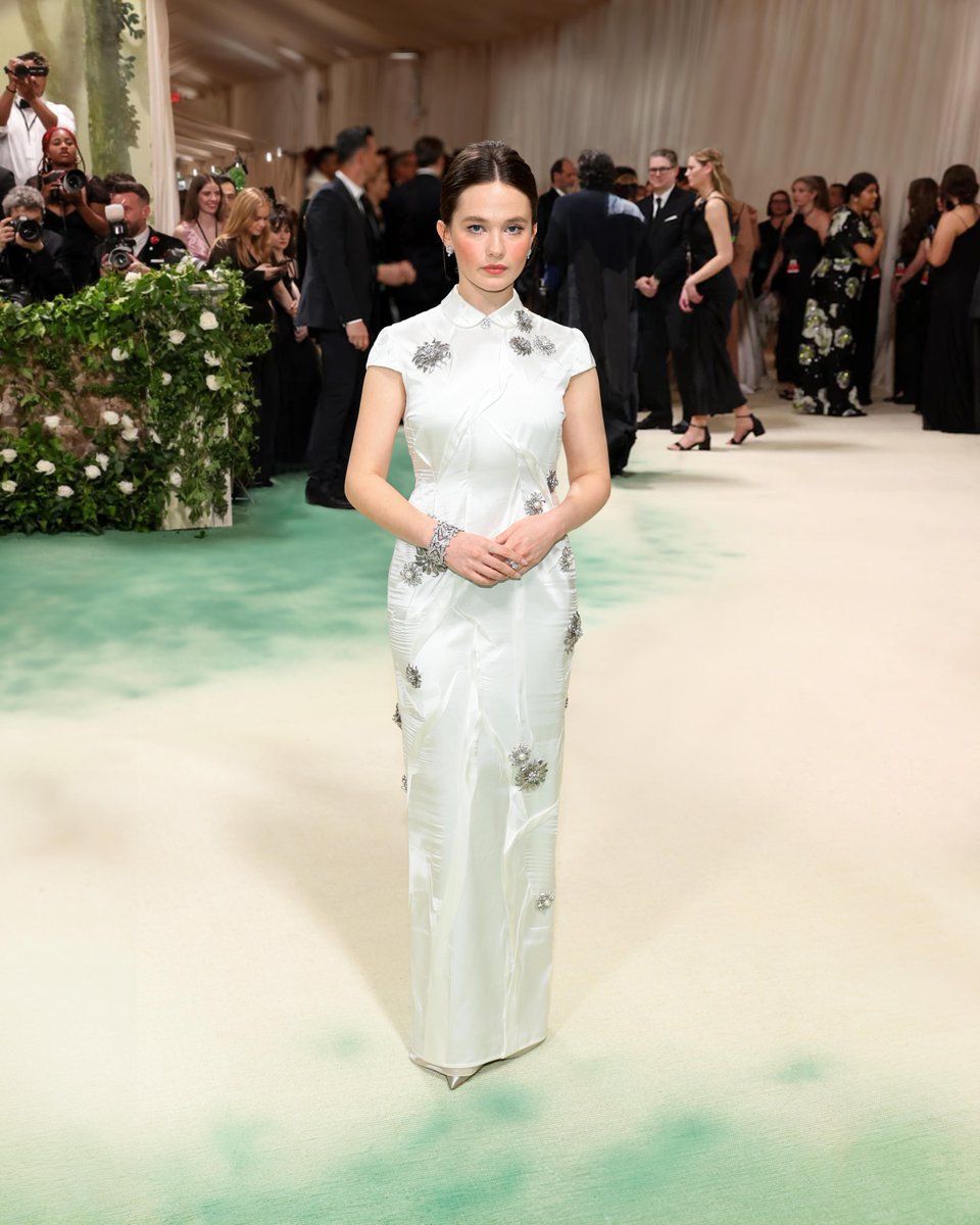 #CaileeSpaeny wore a Miu Miu custom ivory crepe satin dress with all-over metal, crystal and pearl floral embellishments, completed with grey satin pumps while attending the 2024 #MetGala celebrating the opening of “Sleeping Beauties: Reawakening Fashion” in New York.