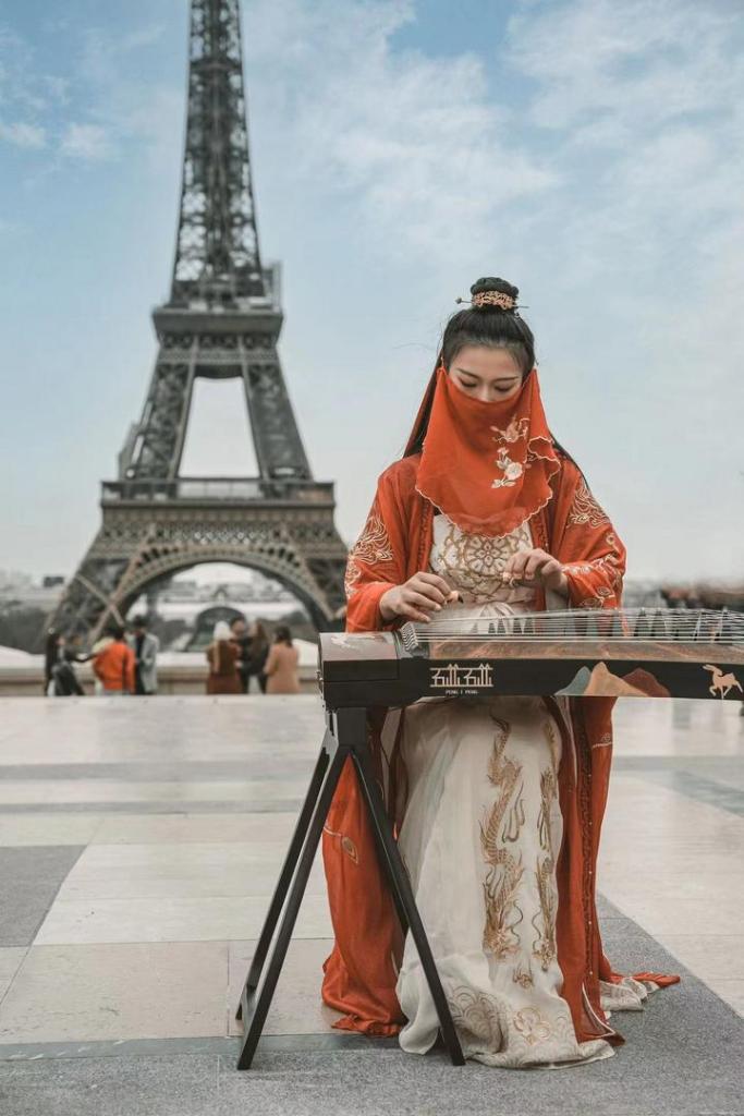 A Chinese girl, Peng Jingxuan performs Guzheng on a street in Paris, France.

#ChinaFrance60 #ChineseCulture #chinesefashion
