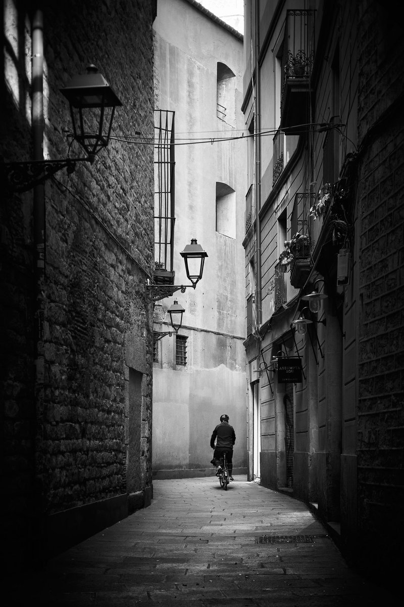 Riding through the alleys from another time 📍 Carrer de Montjuïc del Bisbe, Call Jueu, Barri Gòtic, Ciutat Vella, Barcelona 📸 Fujifilm X-T4 📷 Fujinon XF 35mm F2 R WR ⚙️ ISO 400 - f/2.0 - Shutter 1/320 #StreetPhotography #BlackAndWhite