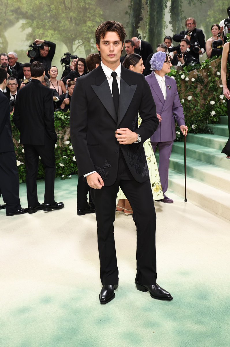 Nicholas Galitzine wore a custom look by Silvia Venturini Fendi to the 2024 Met Gala. The #FendiAmbassador chose a fitted wool jacket with a satin lapel and embroidered flower, a matching embroidered tie, solid wool trousers with a side band, and black leather boots. #MetGala…