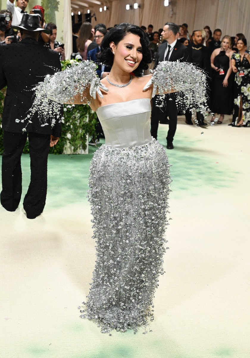 Raye wore a custom Fendi look by Kim Jones to the 2024 Met Gala. The star chose a gown with a silk bustier and an organza skirt embellished by three-dimensional floral embroidery paired with matching silver fringed gloves, drawing from #FendiCouture Spring/Summer 2024. #MetGala…