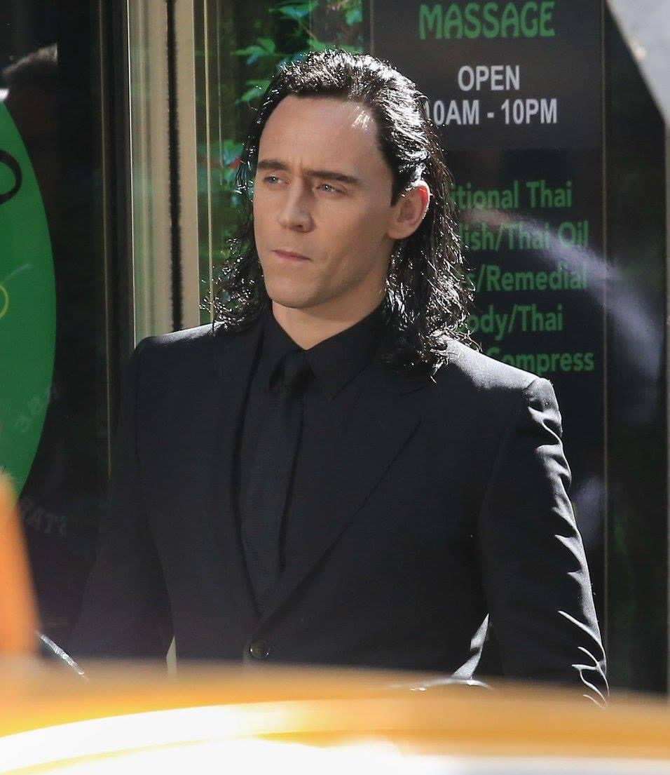 Tom Hiddleston in his Loki Ragnarok Gucci suit in front of a massage parlor is…a moment
