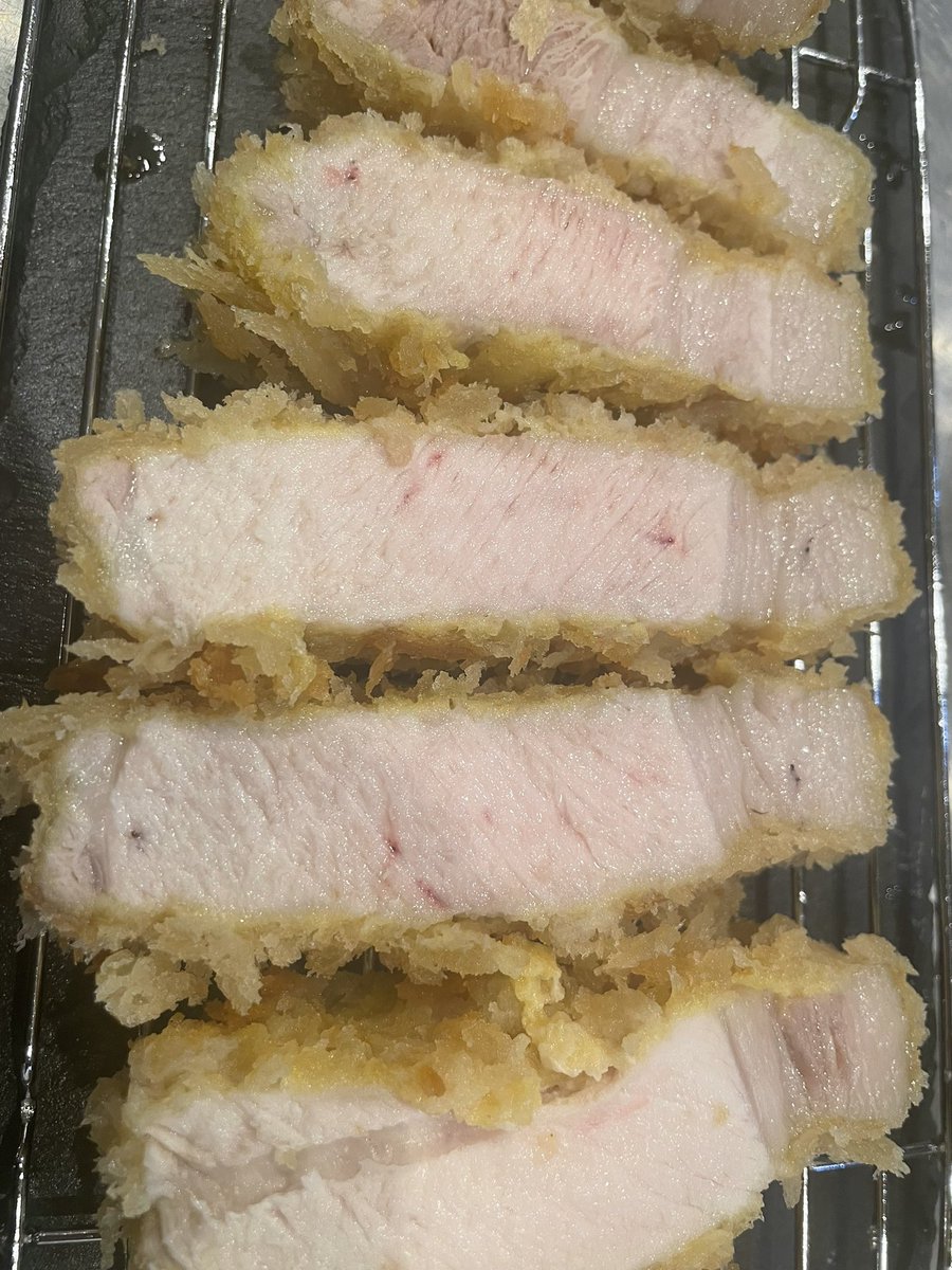 sekime_wacca's tweet photo. 【豚肉の加熱について】

結構、これ書くの悩んだんですよね。下手すると物議を醸しそうで…

カツカレーやるにあたって結構いろいろと実験したんですよ。

まず豚肉の火入れの前提として食品衛生法の加熱殺菌基準では63度30分相当の加熱が必要とされているんです。

63度30分相当ですので75度だと1分、70度だと4分、90度だと1秒となります。低温調理の場合、主要食中毒菌の生育限界の55度でなら5時間必要となります。

さて、なぜ豚肉が牛肉や鶏肉と違って加熱条件が違うのか？それは豚って生育過程で高確率でE型肝炎ウ イルスに感染し、それは肉の内部汚染であって残存もしている可能性があるからとのことです。SPFも肝炎は対象外ですしね。

E型肝炎ウ イルスを不活性にする安全基準として63度30分相当が設定されています。（一応、厚生労働省の実験データとしては68度5分でも検出されなくなったそうです。）

さて、話を戻します。

昨今のロゼに火入れしたとんかつやミシュランとか立派なレストランで出てくる豚肉のソテー。

63度30分相当の基準を満たしてると思いますか？

私見ですが、限りなくアウトに近いと思う所も少なくありません。

下の写真はうちのとんかつです。
左は肩ロース、右はロース。

ロースって火を入れるとすぐ白くな���ます。一方、肩ロースは白くなりにくく赤さを保ちやすいです。

ちなみにリブロースだと、脂側のかぶりの部分は肩ロースと同じ肉質なので赤いけど、下の部分のロース芯は白くなります。

さて、このポストで何が言いたいかというと、低温調理以外の加熱方法で63度30分相当基準で加熱した場合、ロースやヒレはほぼ確実に中心までしっかりと白くなるという事です。

一方、肩ロースは赤さを残す事がギリギリ可能です。いわゆるロゼですね。なので、同じ温度と時間でも部位の違う左と右の写真の赤さが違うのです。

ちなみに、低温でじっくり揚げる昨今流行りのとんかつ。

当店の実験では厚さ2mmのカツを120度で10分揚げると、揚げ上がりの芯温は47度。これでは話になりませんので15分間揚げます。すると揚げ上がりの芯温は62度。そしてピーク温度が3分50秒後で66度。そして10分後に65度と下がってきます。

その10分後の65度の段階でカットした断面が4つ目の写真。
見た感じは十分揚がっているように見えますね。でも、63度30分相当の基準は満たせていません。

厚生労働省データの安全を見ないでギリギリの68度5分相当だと、ギリギリ満たせているか満たせていないかの境界線です。

ちなみに、150度6分30秒だと、揚げ上がりが56度、4分15秒後の72度をピークに6分15秒で71度と下がってきます。これだと完璧に63度30分相当を満たします。でも、ロースの場合はうっすらピンクの部分すらほぼありません。

つまりですね…ロースやヒレで中心がピンクだと、おそらく食品衛生法の基準は満たせていない可能性が高いと思ってくださいという話です。あ、肩ロースはピンク残しは可能ですし、うちのとんかつはピンク残ししてます。

あと、火を入れない方が美味しいかどうかの話。

個人的には焼肉ではまあまあ焼きます。なぜかというと、焼いた方が芳香成分やアミノ酸などが複雑な化学反応を起こした結果、美味しく感じる香りや成分が増すからです。

つまり、レアよりは火を入れた方が美味しい条件が増えるんですよね。ただし、肉汁は失われますし食感は固くなっていきます。なので、表面こんがり、芯はしっとりが理想です。

とんかつの場合、せっかく生産者の方が心血注いで育てられている訳ですから、料理人としてはポテンシャルのMAXを引き出したいですよね。

柔らかく、ジューシーで、でもレアではない火入れ。そして食品衛生法の基準を満たす…これ、ほんとめちゃくちゃ難しいんですよね…