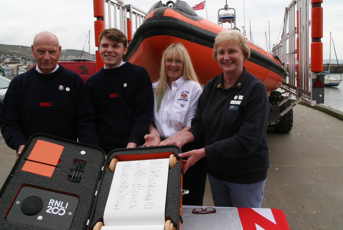 The @RNLI’s historic scroll, marking the 200th anniversary arrived in Lyme Regis today to be signed by 4  volunteers: Krys Lavery, lifeboat shop manager, Petrina Muscroft, lifeboat station visits officer, water safety team representative Ian Marshall & the  crew member Sam Ellis