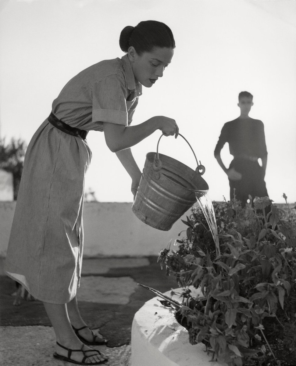 Herbert List. The wife of the American painter Carlyle Brown, Margery Brown, waters the plants. Foria d'Ischia, Italy. 1952.