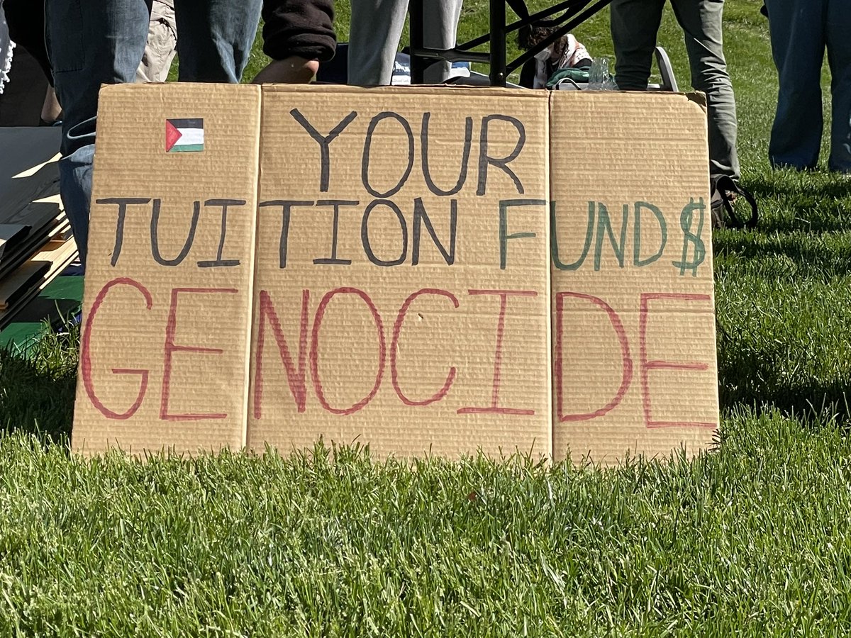 andrew_mmiller's tweet photo. At today’s IU Divestment Coalition protest — Protestors are setting up tarps, signs and drums. Police are walking around the protest site, and new signs saying that overnight camping is not permitted at Dunn Meadow are set up. https://t.co/7GSn2KJbcK