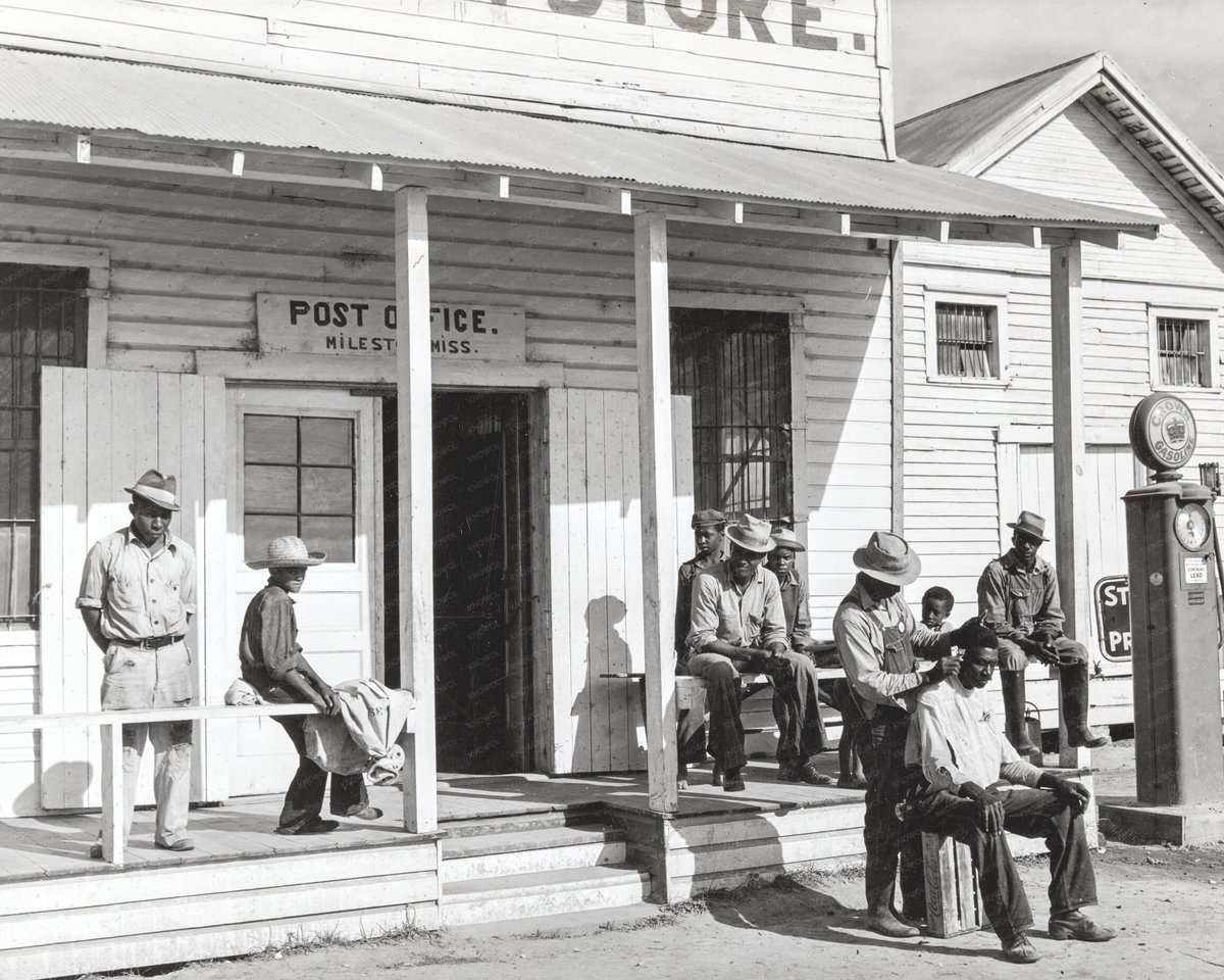 Sharecroppers cut each other's hair in front of plantation store after being paid. A Saturday in Mileston, Mississippi 1939.

#Mileston #Mississippi #VintagePhotography