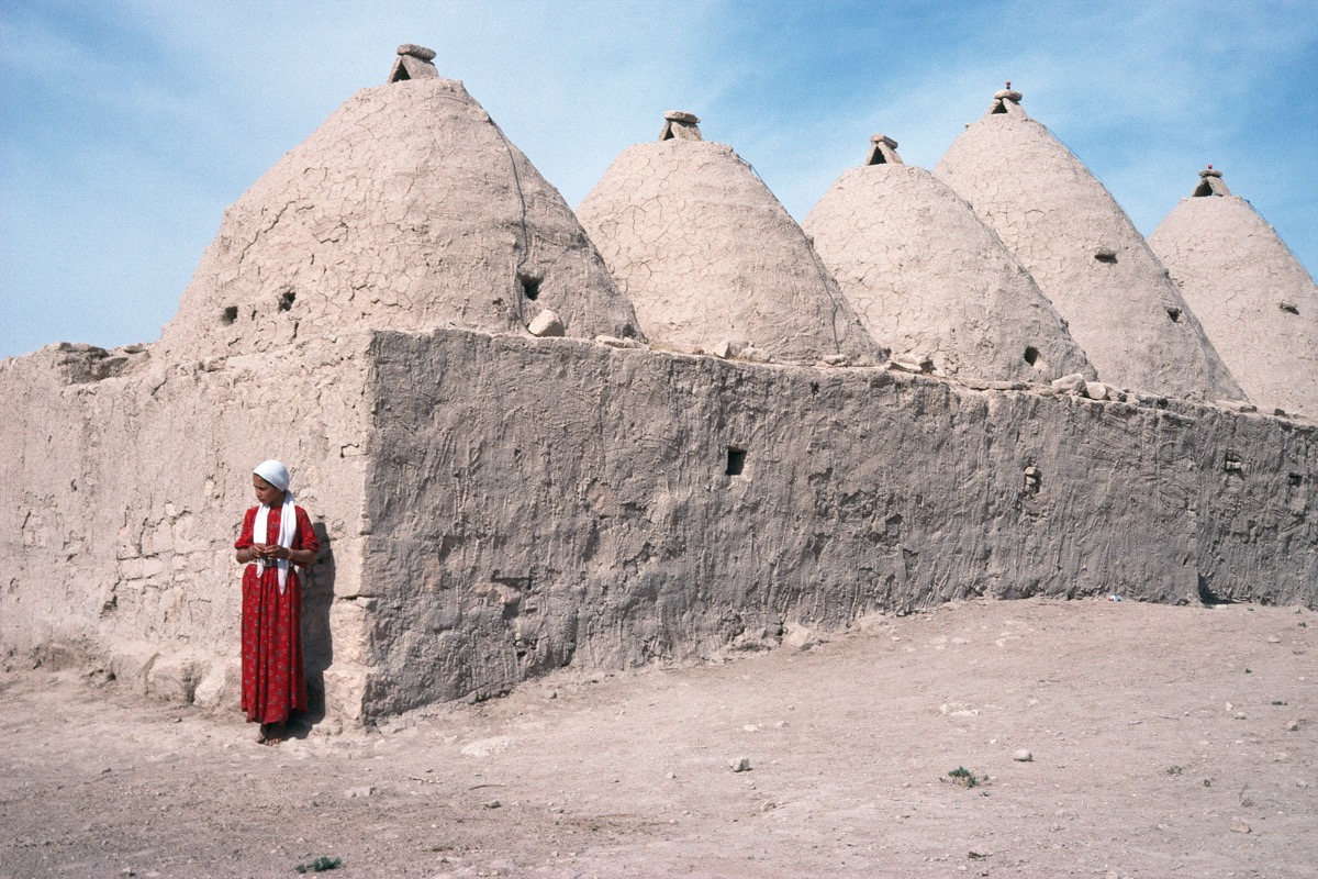 #PhotoFriday A woman wearing a long embroidered dress, standing outside one of the interlinked domed houses unique to Harran in Anatolia. Photograph by Sheila Paine. Harran, Şanlıurfa, Turkey. 1992. Taken from 'Embroidered Visions', viewable online at prm.ox.ac.uk/event/embroide…