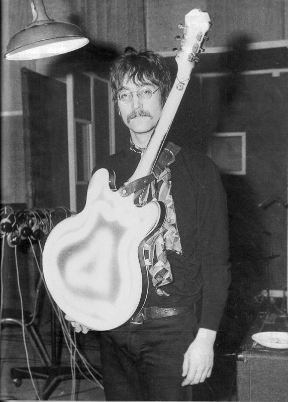 john showing off the back of his recently spray painted epiphone casino, march 1967

john sprayed the back of the guitar with white & gray paint but left the sunburst finish on the front. in '68, he had it professionally sanded back to its original finish