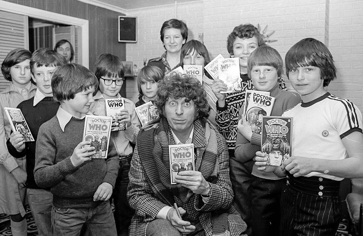 Tom Baker with fans holding Doctor Who books. #TomBaker #DoctorWho #FourthDoctor