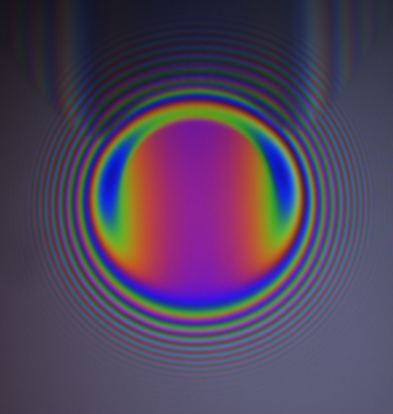 You are looking at the prismatic recursion of a quetelet ring set formed by a conoscopy of a lubricant. The aim was to visualize the elastohydrodynamic pressure zones. The exponentially decrementing hue shift of this photodiagraphic is unfortunately slightly off center.

Why do I…