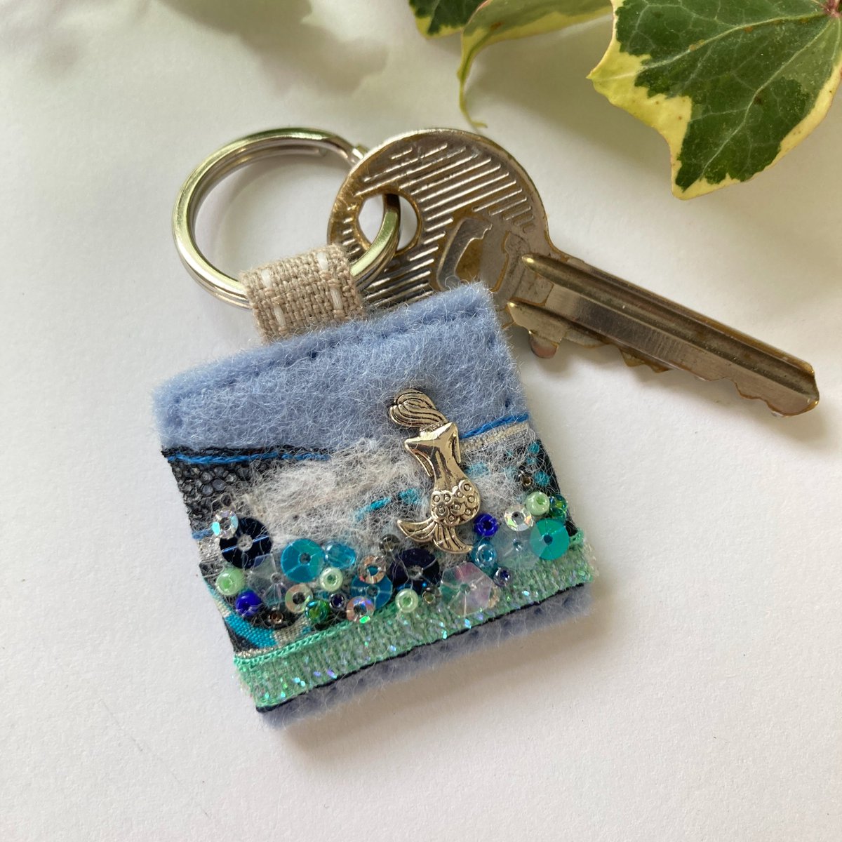 Dreamy mermaid hand sewn keyring in pretty ocean colours with tactile trims and sparkly embellishments. Unique accessory gift ideas, handmade in #Lincolnshire by Ellie's Treasures. elliestreasures.square.site/product/mermai… #mhhsbd #Mermaids #shopindie