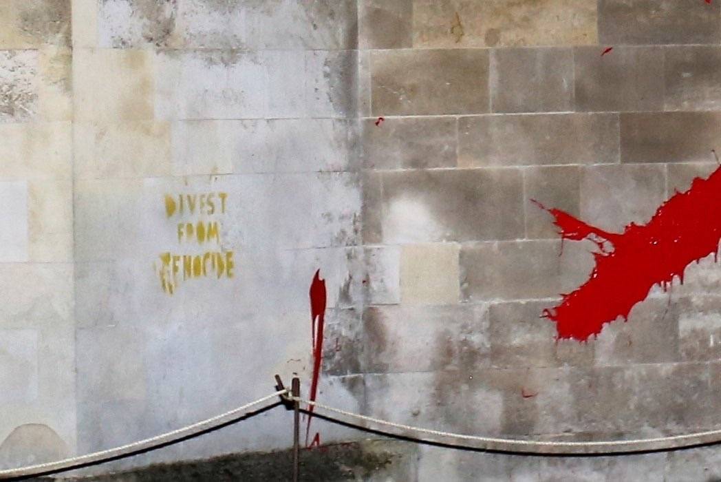 Activists throw paint at Trinity College Cambridge in protest against Israeli arms investments Trinity, Cambridge's wealthiest college, has £61,735 invested in Elbit Systems which supplies Israel with the weapons of genocide