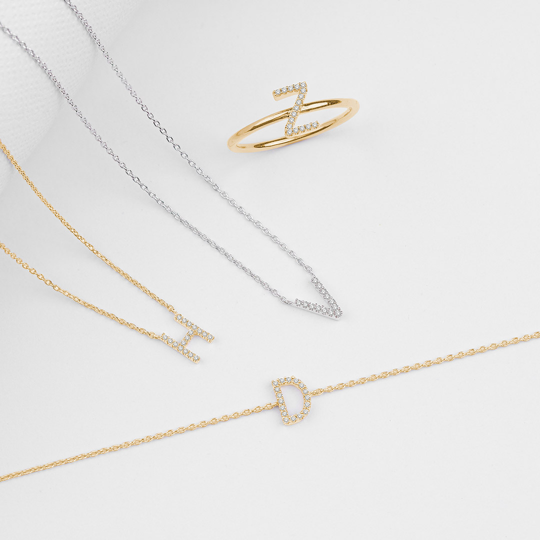 Sleek lines, personal symbols, and a golden shine—every piece tells a part of your story. ✨ Let your initials stand out and sparkle with every turn. #InitialJewelry #PersonalizedPerfection #GoldAndSilver #StorytellingSparkle #AlphabetAccents #MinimalistGlam #ASHI