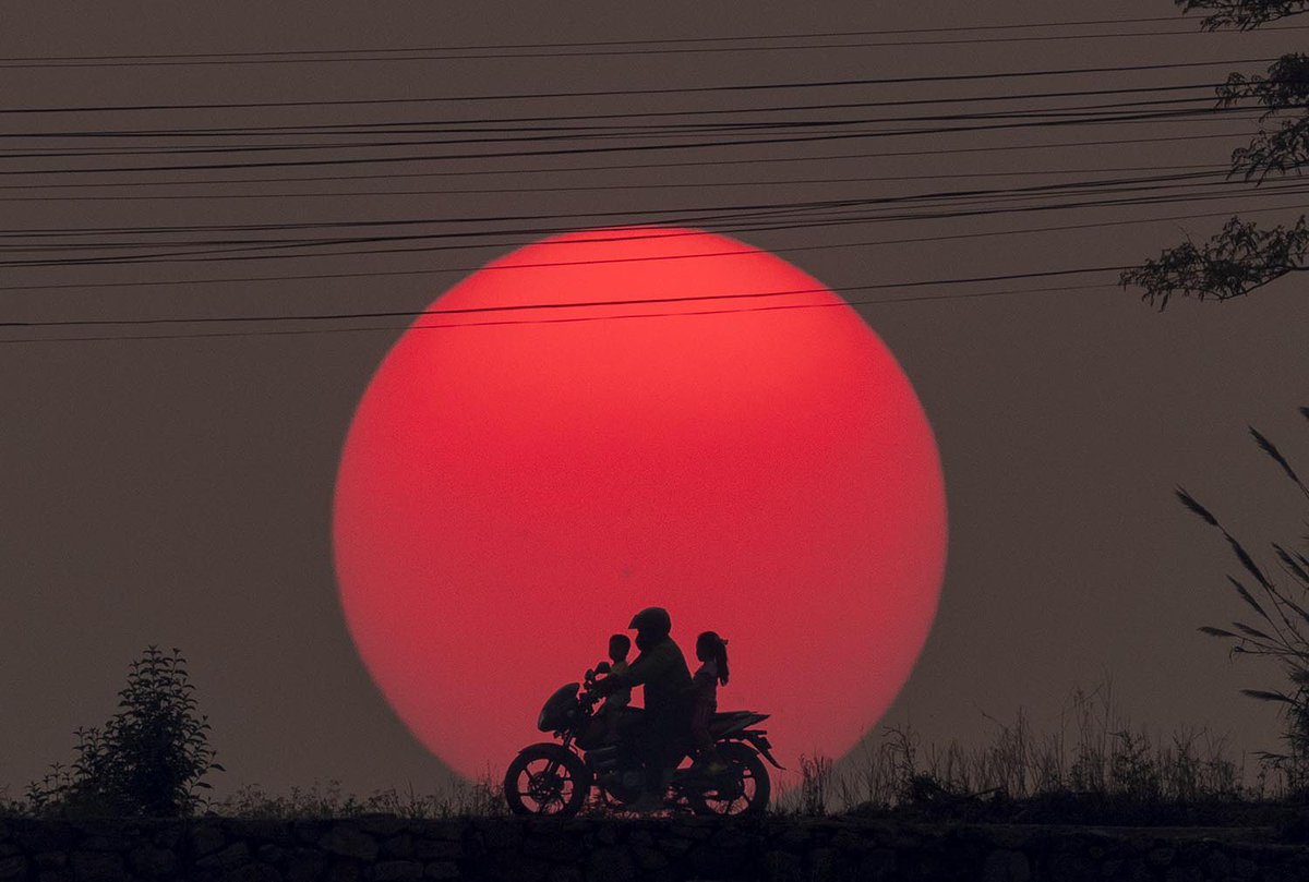 People ride on a motorbike along a road as the sun sets in Kathmandu, Nepal, 26 April 2024. @EPA_Images / Narendra Shrestha