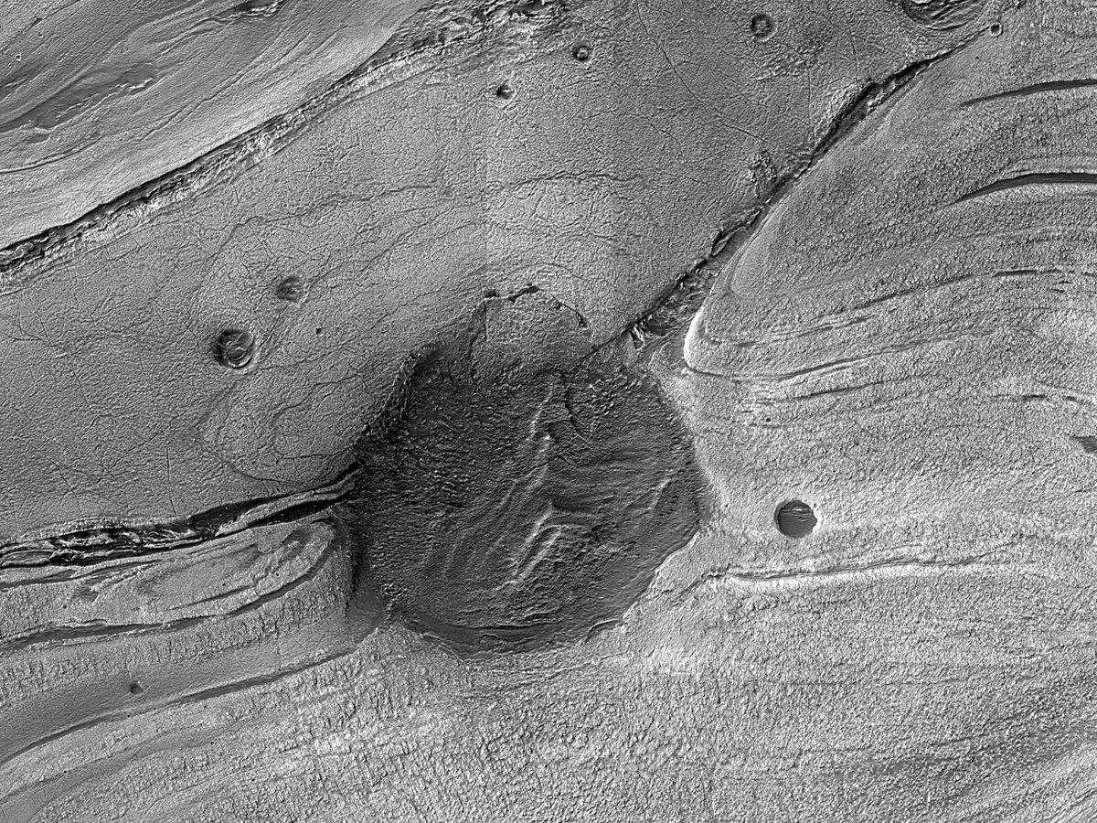 HiPOD: A Great Dark Spot This observation targets a pit partially filled with layered material and surrounded by banded terrain, as seen in Context Camera data . The relationship between the banded terrain and the layered material in the pit is unclear. uahirise.org/hipod/ESP_0822…