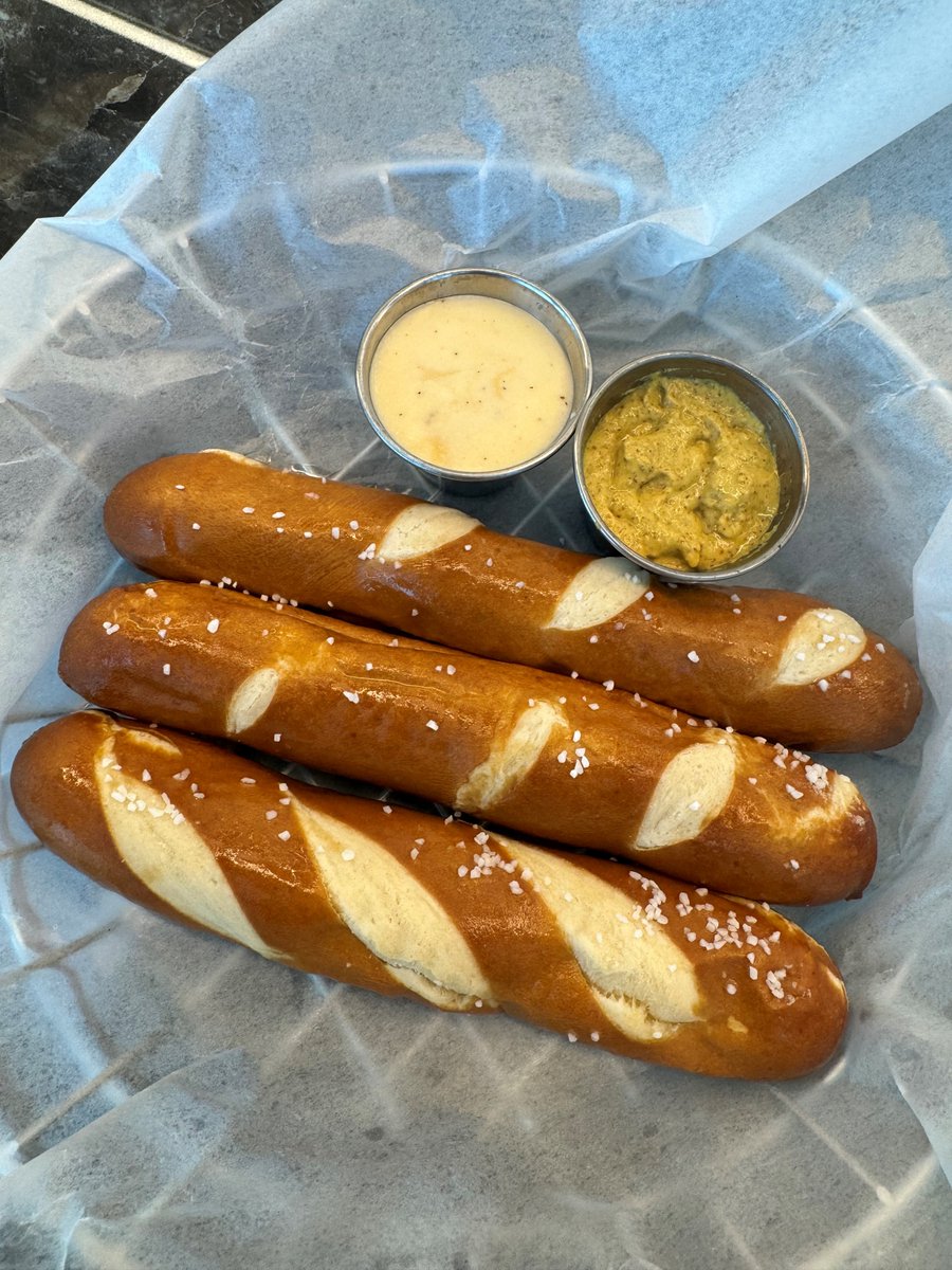 Dip, bite, and repeat. Pretzels make everything better! Stop by Terminal E to grab a pretzel from @bostonharbordistil to celebrate National Pretzel Day. 🥨  It's the perfect pre-flight snack if you ask us! ✈️ #NationalPretzelDay