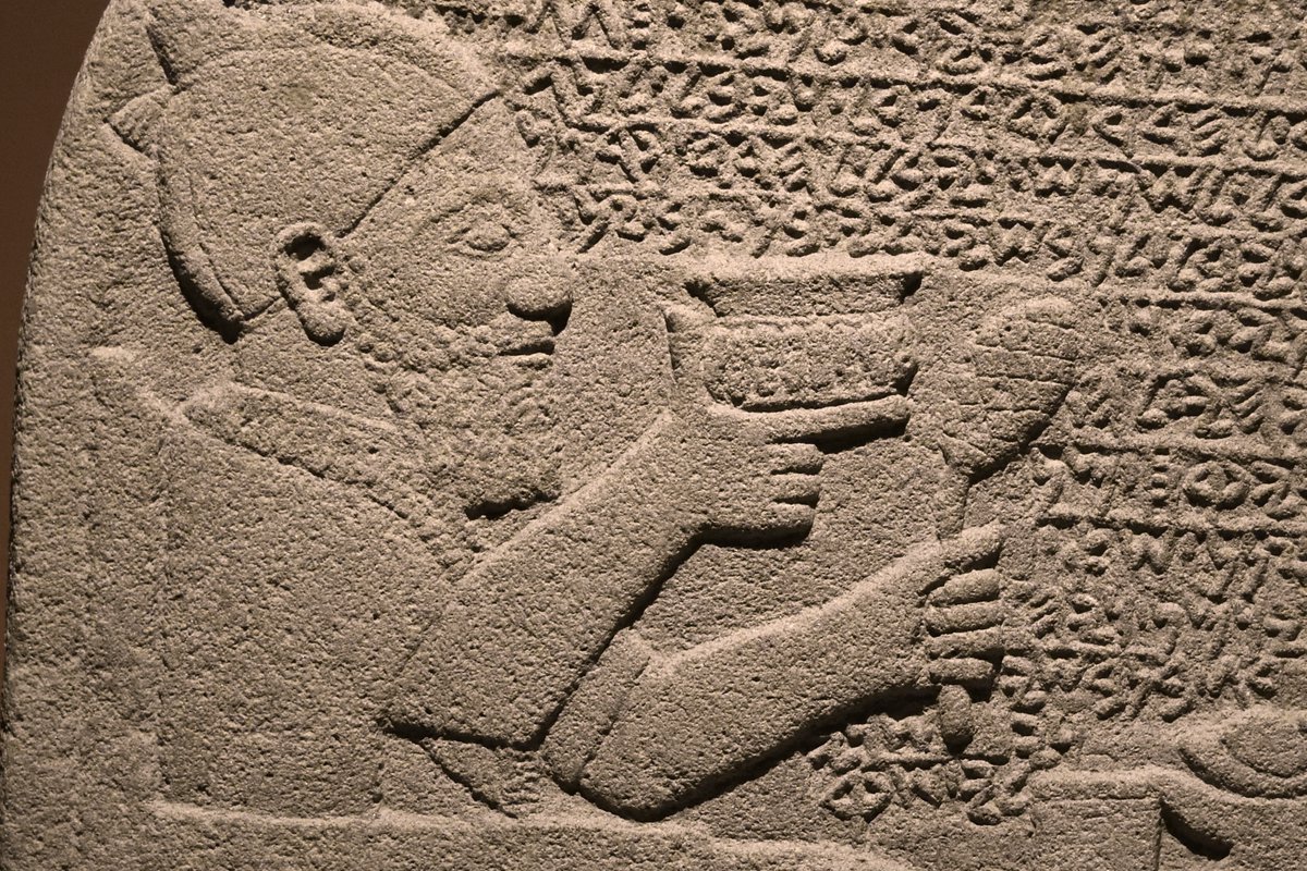 Art historians may say that he is is holding a wine cup, but the Kuttamuwa stele (8th c. BCE) is very clearly the earliest attestation of finger guns.