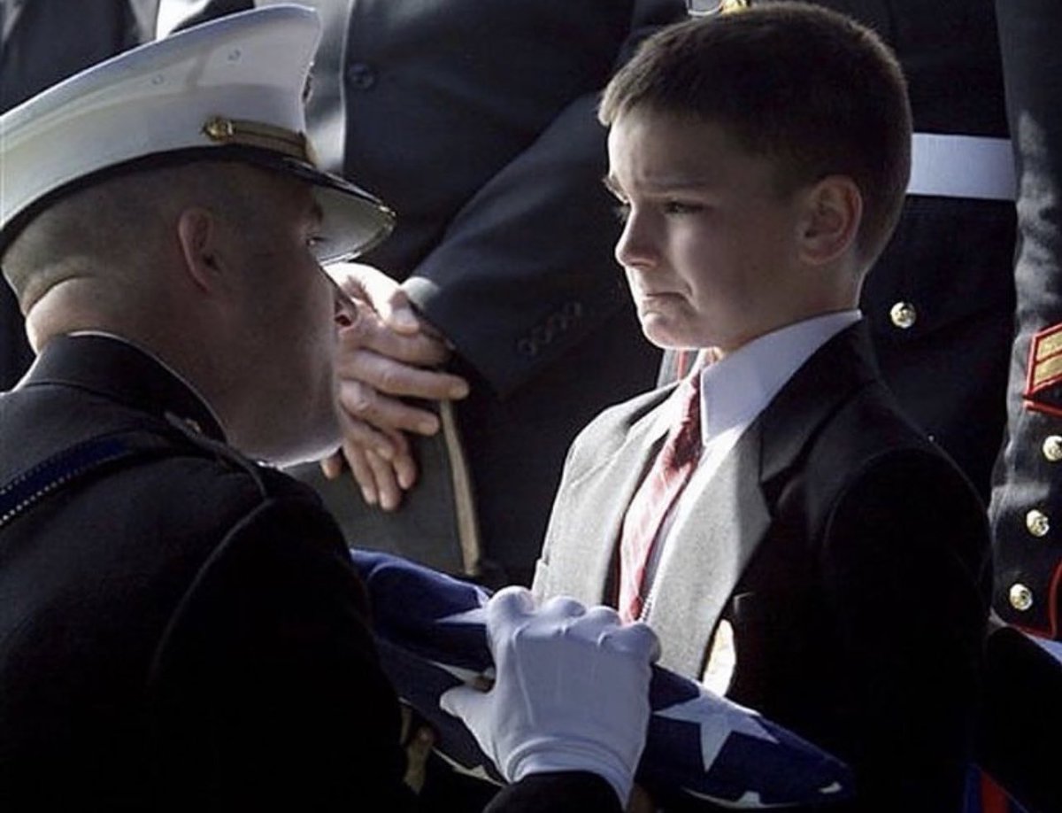 Eight year old Christian Golczynski accepting the flag for his father, Marine Staff Sgt. Marc Golczynski, during his memorial service.