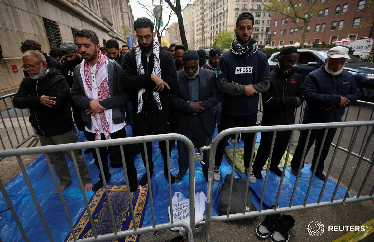 A group of Muslims stand during a prayer outside Columbia University campus as they gather to support a student protest encampment in support of Palestinians, in New York City, U.S., April 26, 2024. REUTERS/Mike Segar