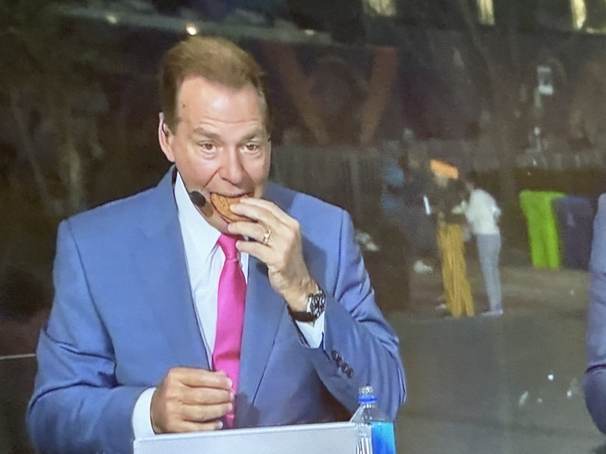 Nick Saban eats an oatmeal creme pie on the ABC set during the third round of the NFL draft. “They never even sent me a free box,” Saban says when asked about the publicity he’s given Little Debbie over the years.