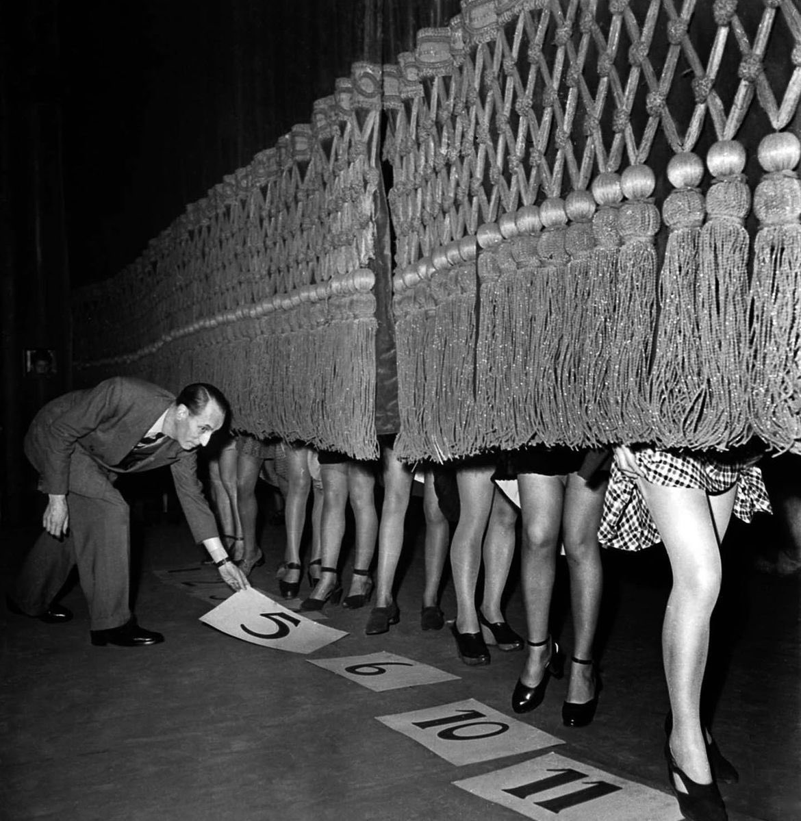 Man judging a 'Prettiest Legs' competition in Paris, 1950