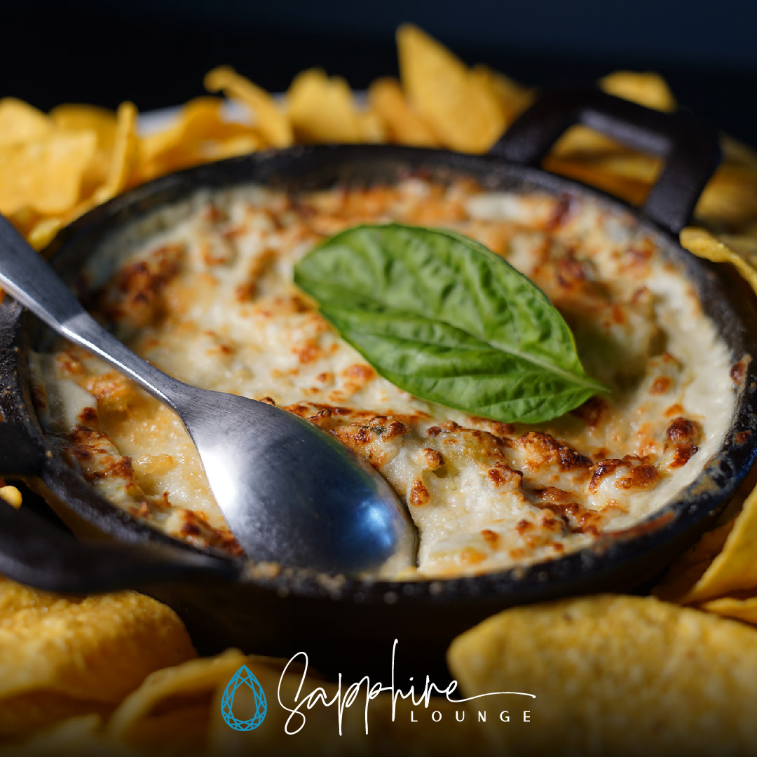 Have you tried our Oven Baked Artichoke Dip? It's cheesy, garlicky goodness and pairs perfectly with a cold drink and good friends. #sapphirespokane #spokaneeats #artichokedip