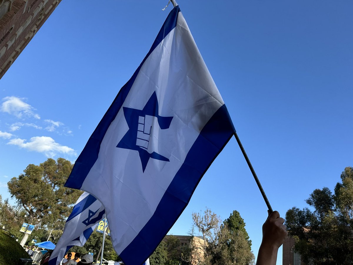 Someone brought a Jewish Defense League flag on the counter protestors side to the UCLA Gaza Solidarity Occupation. The JDL has in the past been described as a violent terrorist group by the FBI and is suspected of multiple terrorist acts.