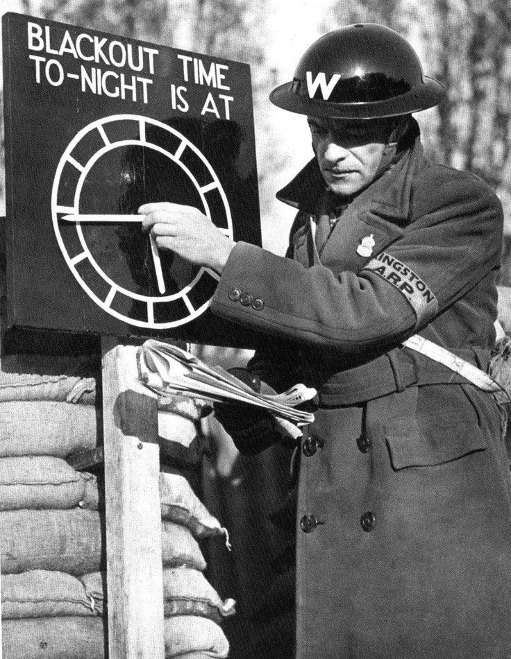 Setting the clock on the blackout time indicator for an evening in London, November 1939.