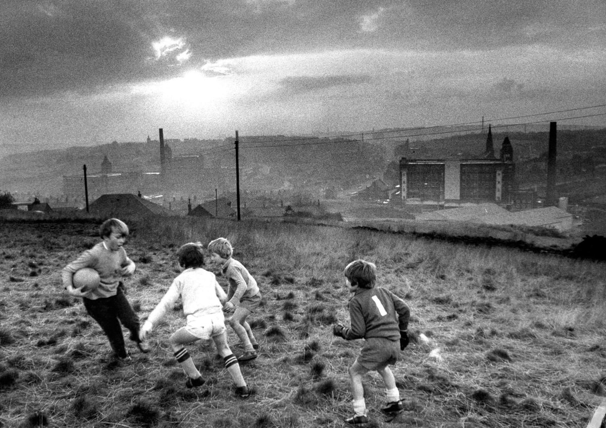 Morning all. Boys playing football on a hill above Oldham, 1982. Photographer Don McPhee.