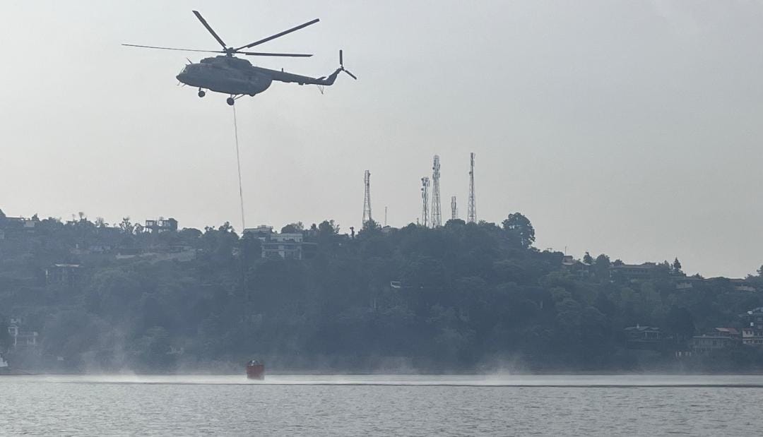 IAF_MCC's tweet photo. With a forest fire building up in vicinity of an Air Force Station near Nainital, #IAF activated its aerial fire fighting capability, employing a Mi-17 V5 helicopter for undertaking Bambi Bucket Ops. https://t.co/2wLbTjW5m8