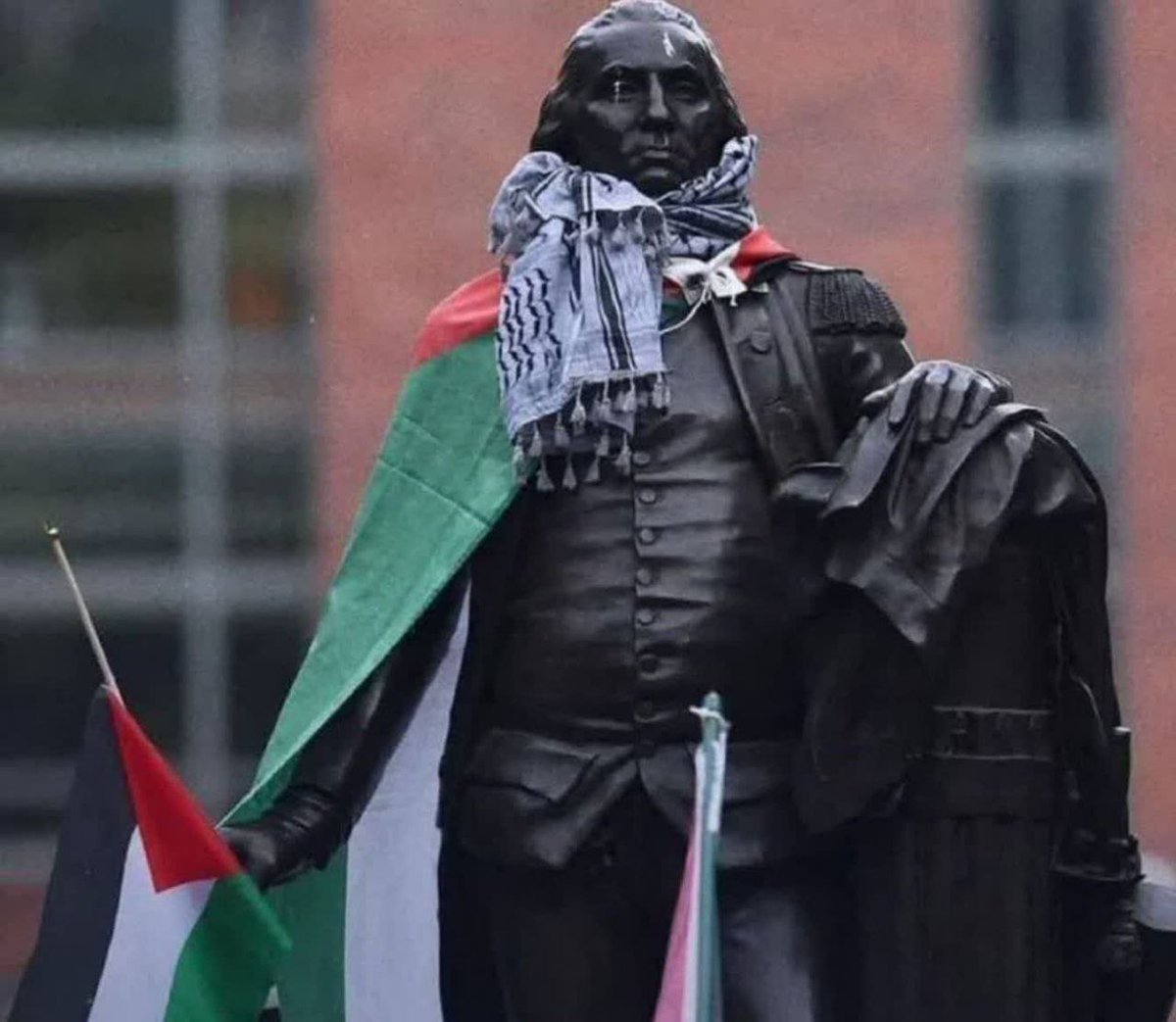 Chafieh dan bendera Palestina di pundak pendiri Amerika Mahasiswa Amerika, yang memulai aksi duduk dan protes di universitas beberapa hari yang lalu, memasang Chafieh dan bendera Palestina di bahu patung salah satu pendiri Amerika.