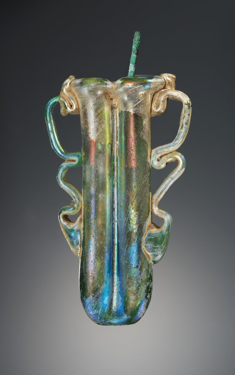 This stunning #Roman bipartite eye makeup container @GettyMuseum is made of free-blown colourless glass & was used for Kohl. 3rd or 4th Century. The 2 parts of the vessel are formed by a tube folded upon itself. It includes a thin bronze applicator. #romanmakeup #romanglass